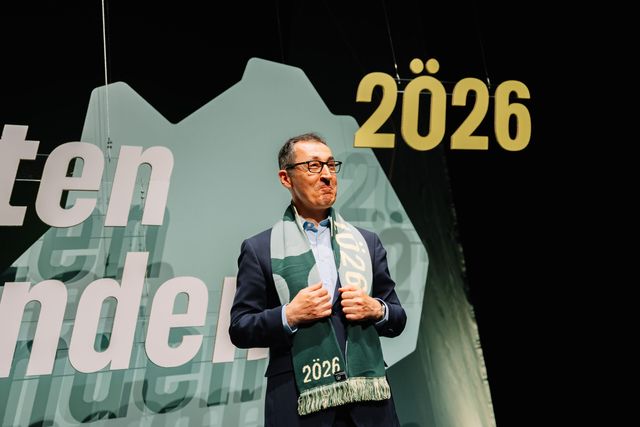 Cem Özdemir mit Wahlkampf Schal auf dem 2Ö26 steht vor der Bühnenkulisse des Parteitags der Grünen Baden-Württemberg zu